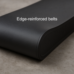 Edge-reinforced bucket-elevator belt—molded side cover with no exposed fabric, subtle rubber texture, photographed on a concrete shop floor.